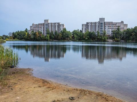 a small lake with buildings in the background