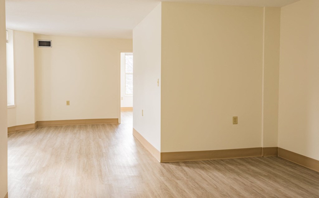 an empty room with white walls and wooden floors