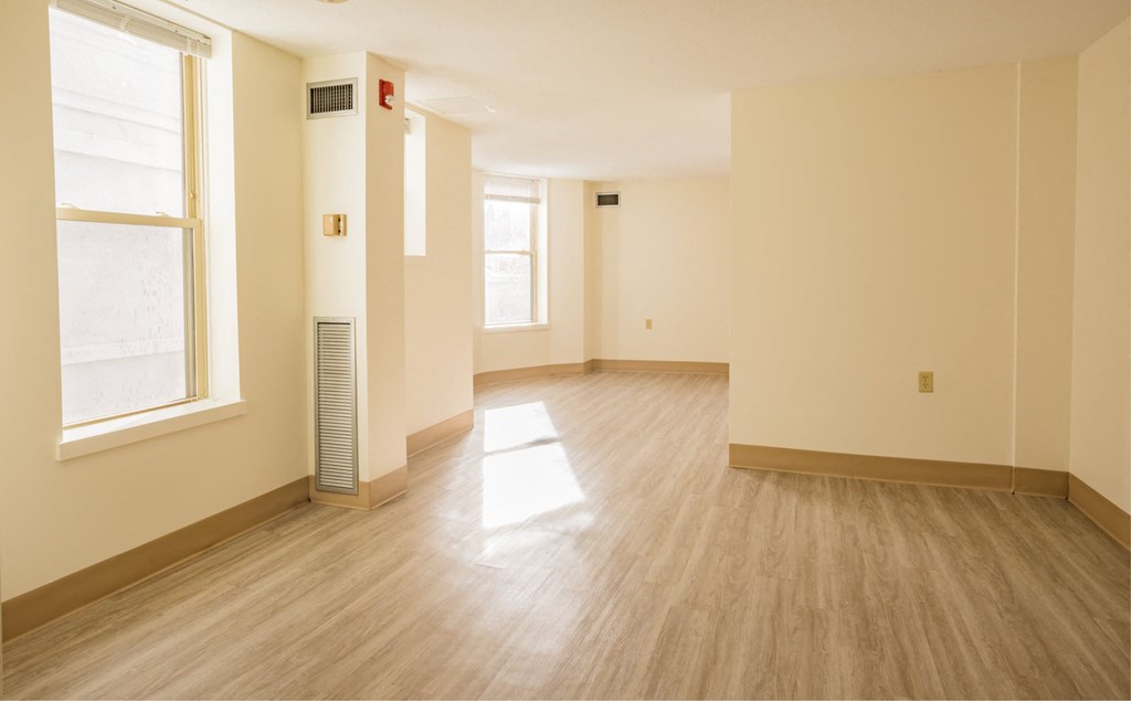 an empty room with a wood floor and a window