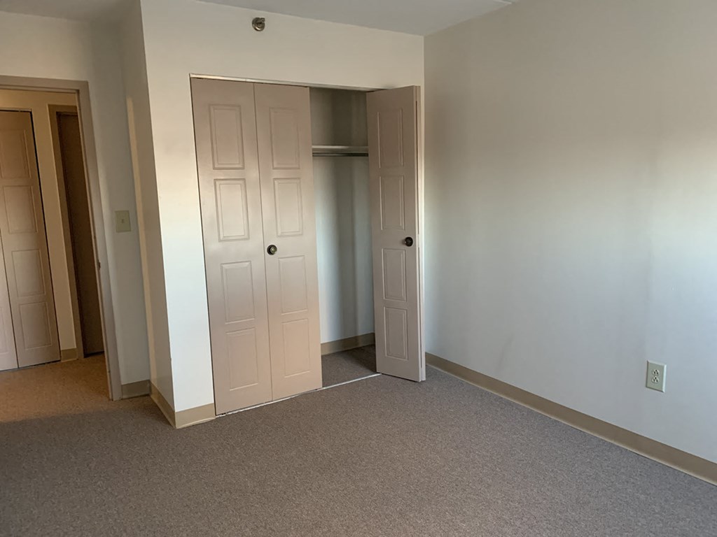 a bedroom with two doors and a closet