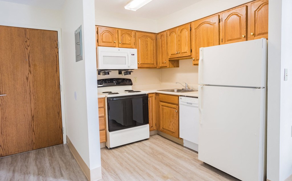 a kitchen with wooden cabinets and white appliances