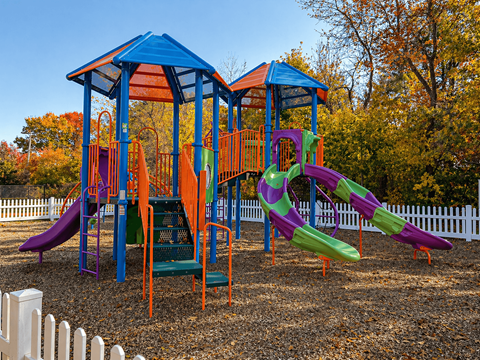 A playground with a blue roof and a purple slide.