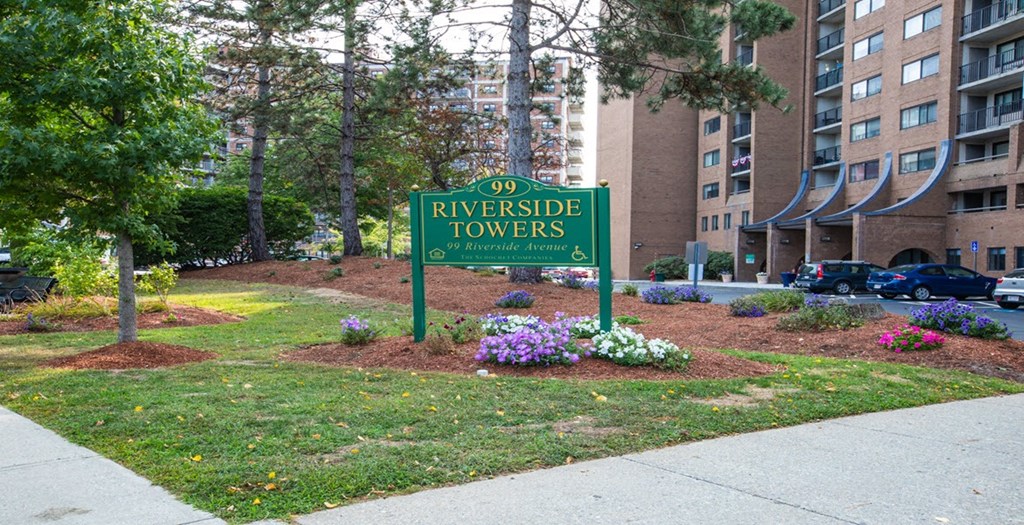 a sign for riverside towers in front of an apartment building