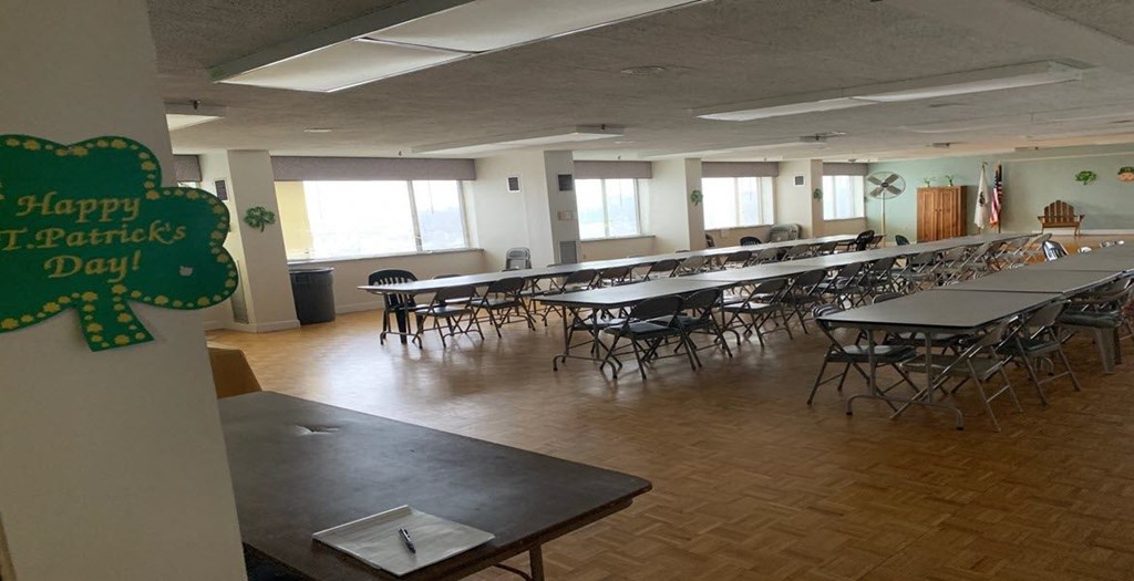 a large room filled with tables and chairs and a sign