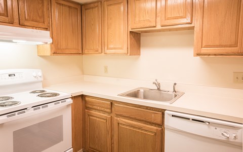 a kitchen with white appliances and wooden cabinets