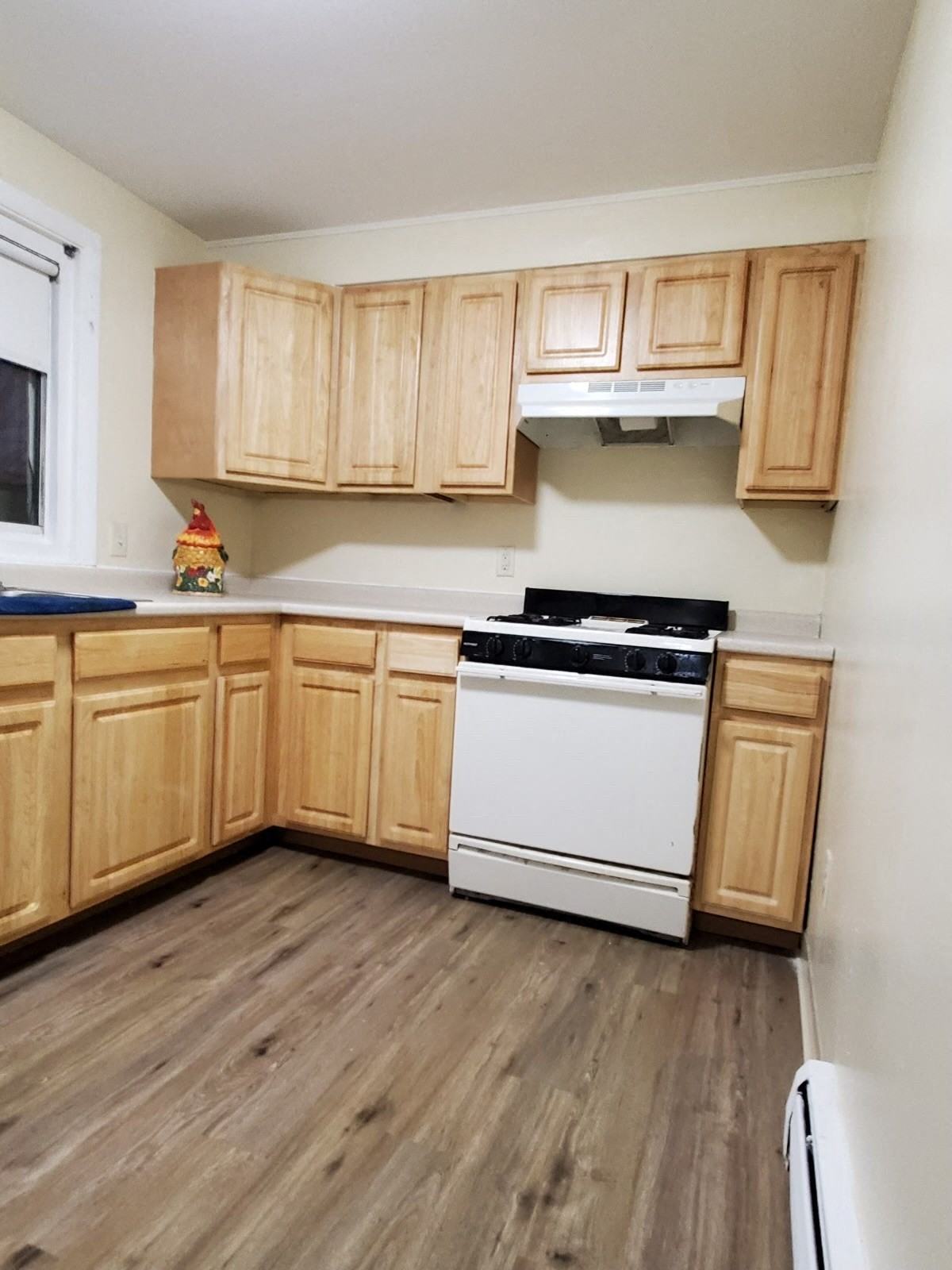an empty kitchen with wooden cabinets and white appliances