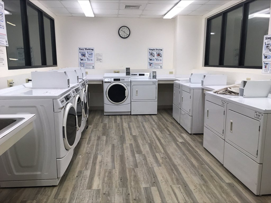 a room filled with washes and dryers in a laundry room