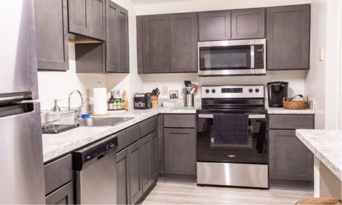a modern kitchen with stainless steel appliances and dark wood cabinets
