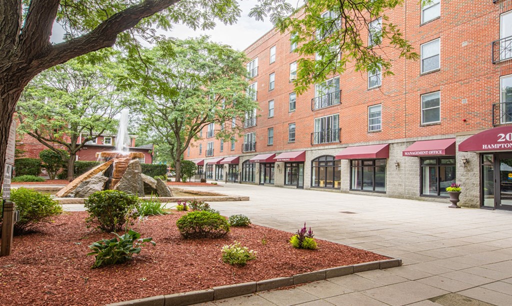 a city street with buildings and a fountain