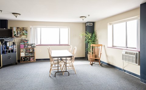 an empty living room with a table and chairs