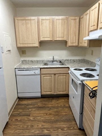 a small kitchen with white appliances and wooden cabinets