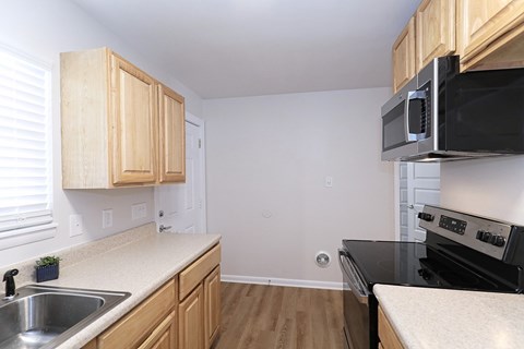 A kitchen with wooden cabinets and black appliances.