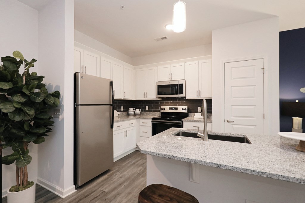 a kitchen with a granite counter top and a stainless steel refrigerator