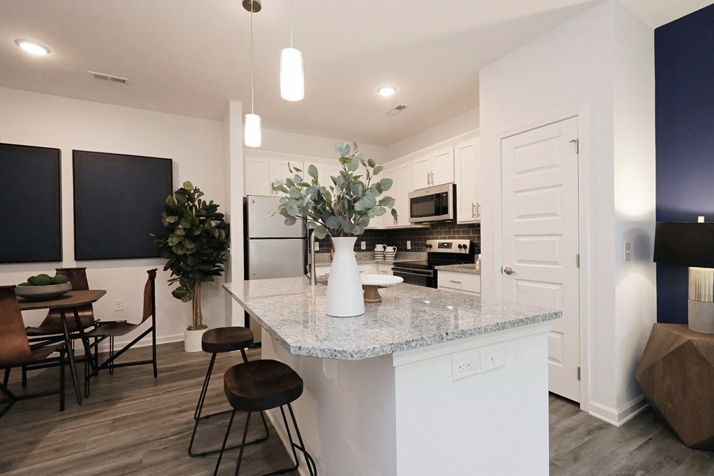 an open kitchen and dining area with a granite counter top