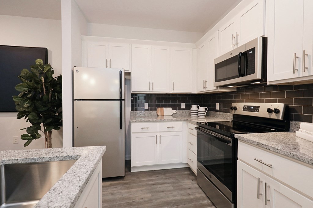 a kitchen with stainless steel appliances and white cabinets