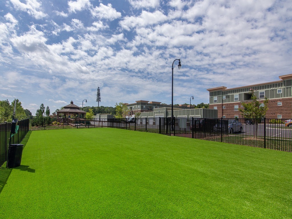 a grassy area with a gazebo and buildings in the background at Ardmore at the Trail, Indian Trail
