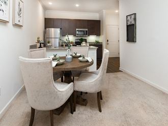 Dining area with a table and chairs and a kitchen in the background at Ardmore at the Trail, Indian Trail, NC 28079
