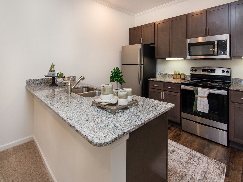a kitchen with granite countertops and stainless steel appliances at Ardmore at the Trail, Indian Trail, North Carolina