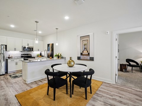 A modern kitchen with a dining table set for two.