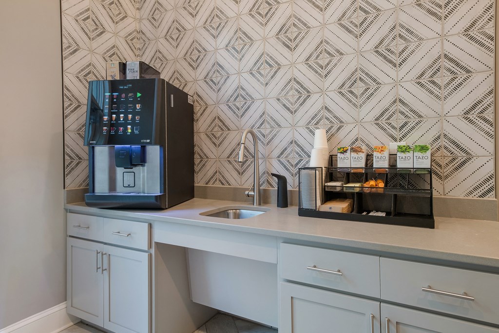 a kitchen counter with a coffee machine and a sink