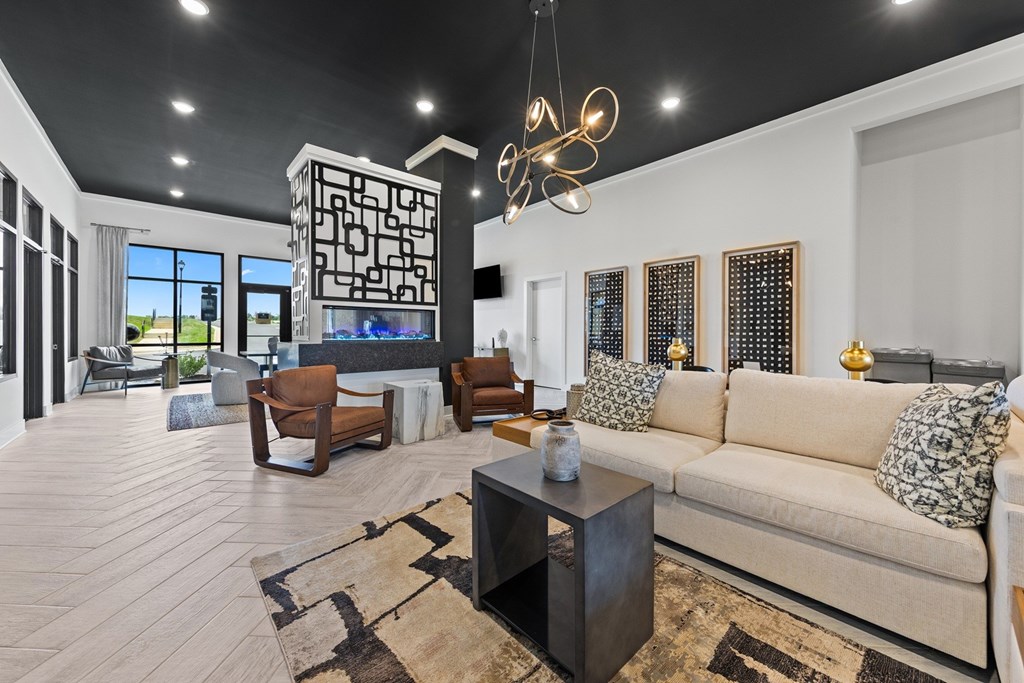 A living room with a large couch, a coffee table, and a TV at Views at Flowers Apartments, Clayton, NC