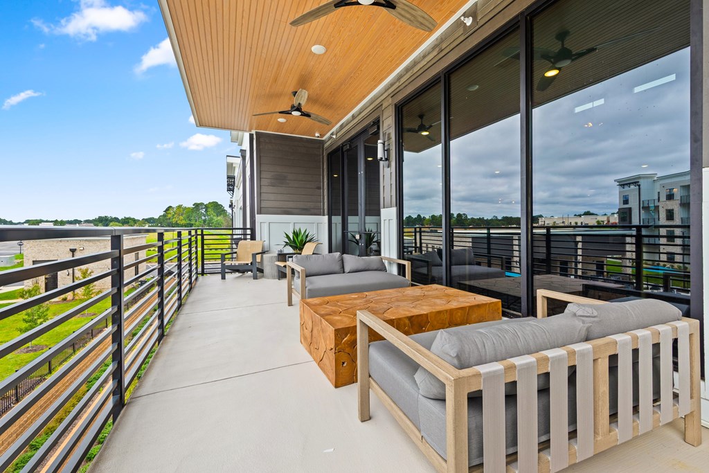 A balcony with a table and chairs overlooking a body of water at Views at Flowers Apartments, Clayton, NC, 27527