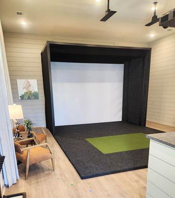 A room with a black screen and a green rug at Views at Flowers Apartments, North Carolina