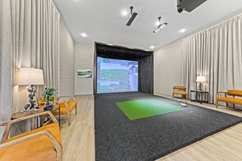 A modern living room with a large screen and comfortable seating at Views at Flowers Apartments, Clayton, North Carolina