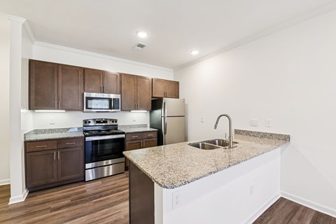 A kitchen with brown cabinets and a granite countertop.