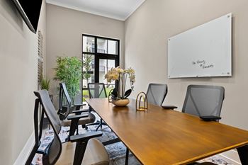 A conference room with a whiteboard and chairs at Views at Flowers Apartments, North Carolina