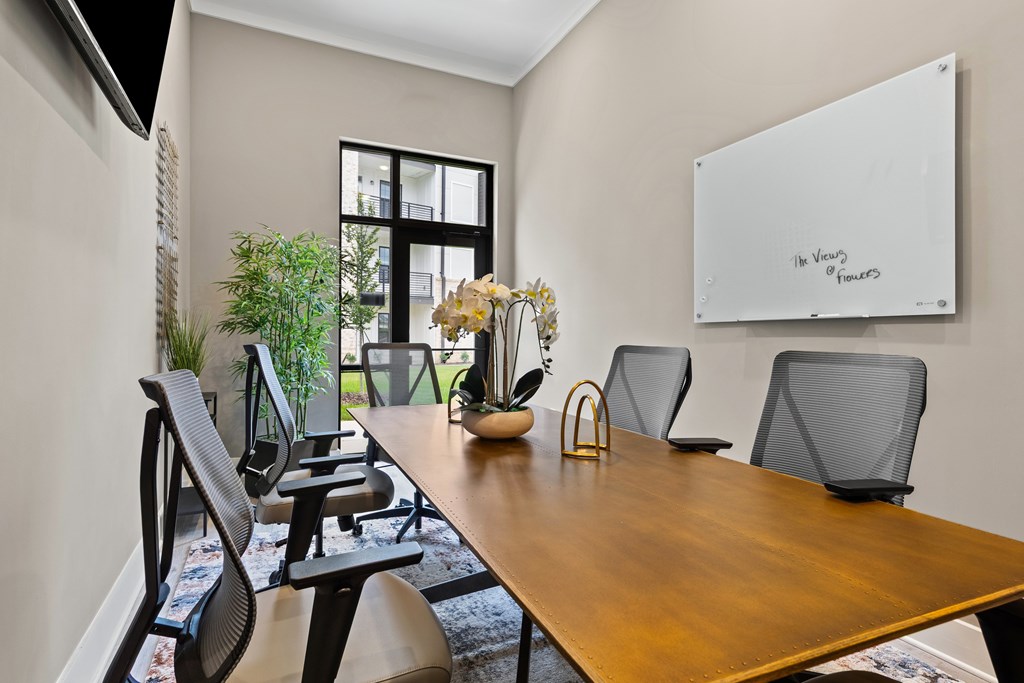 A conference room with a whiteboard and chairs at Views at Flowers Apartments, North Carolina