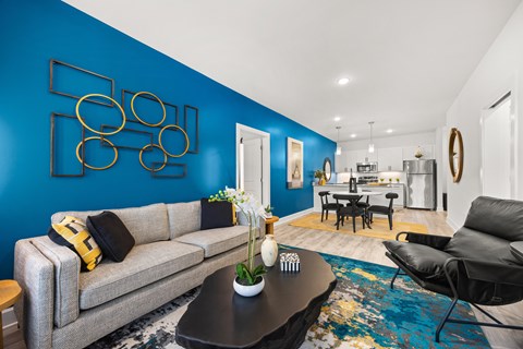 A living room with a grey sofa and a blue wall.