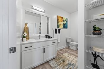 A bathroom with a white cabinet and a white toilet at Views at Flowers Apartments, Clayton