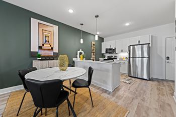 A modern kitchen with a dining table set for two at Views at Flowers Apartments, North Carolina, 27527