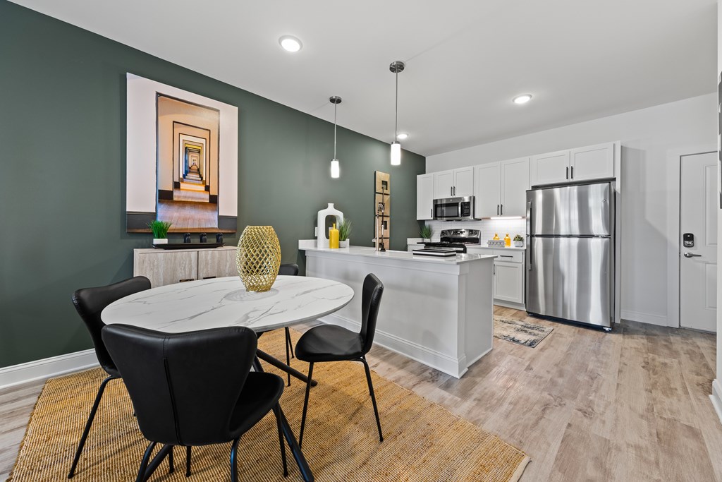 A modern kitchen with a dining table set for two at Views at Flowers Apartments, Clayton, North Carolina