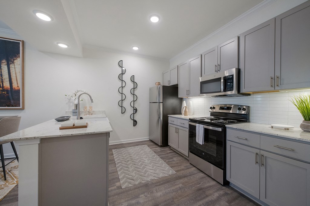 a kitchen with white cabinets and stainless steel appliances