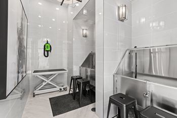 A bathroom with a white tiled wall and a black and white photo on the wall.