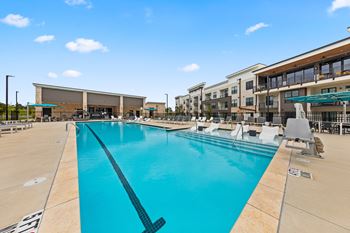 A large swimming pool with a diving board and lounge chairs at Views at Flowers Apartments, Clayton, NC