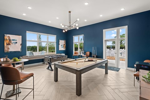 A room with a pool table and a bar area.
