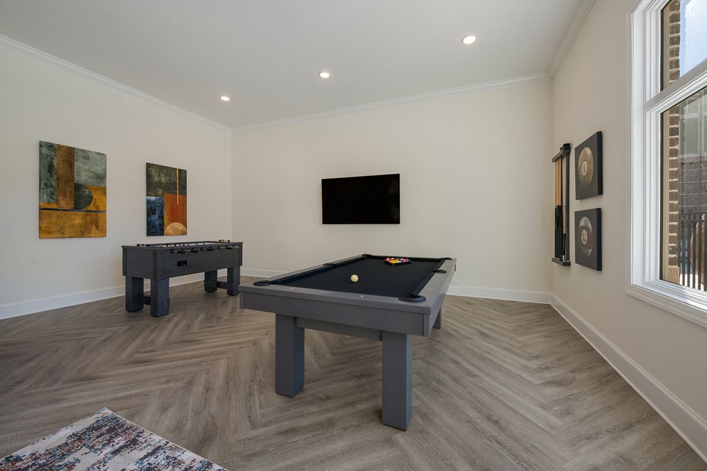 a games room with two pool tables and a television