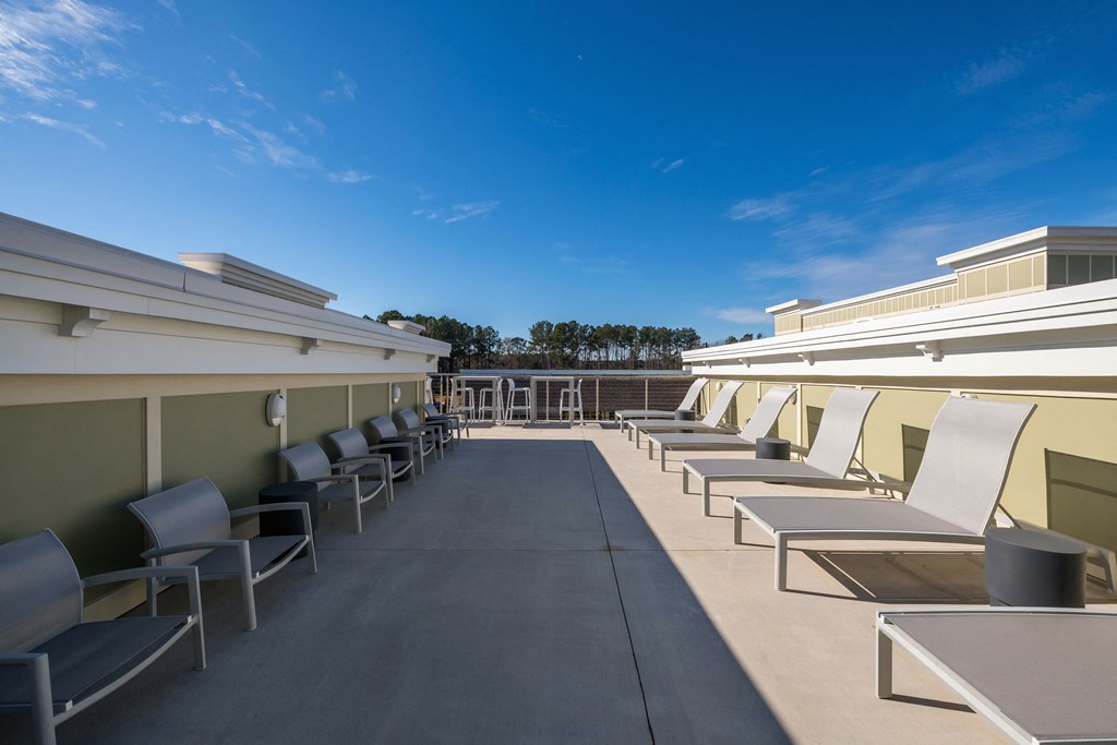 the rooftop patio of a building with chairs and tables