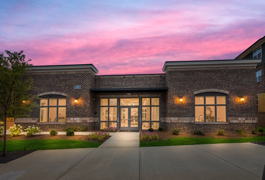 a rendering of a brick building with large windows and a pink sunset in the background  at Ardmore at Bryton, Huntersville
