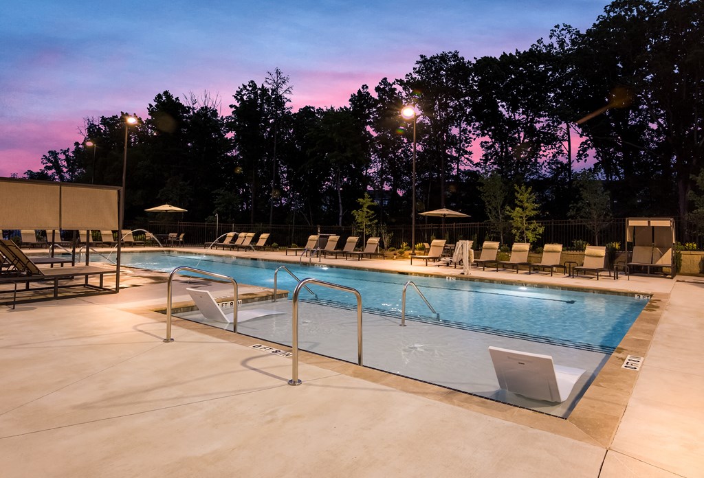 a swimming pool with chairs and trees in the background  at Ardmore at Bryton, Huntersville, NC, 28078