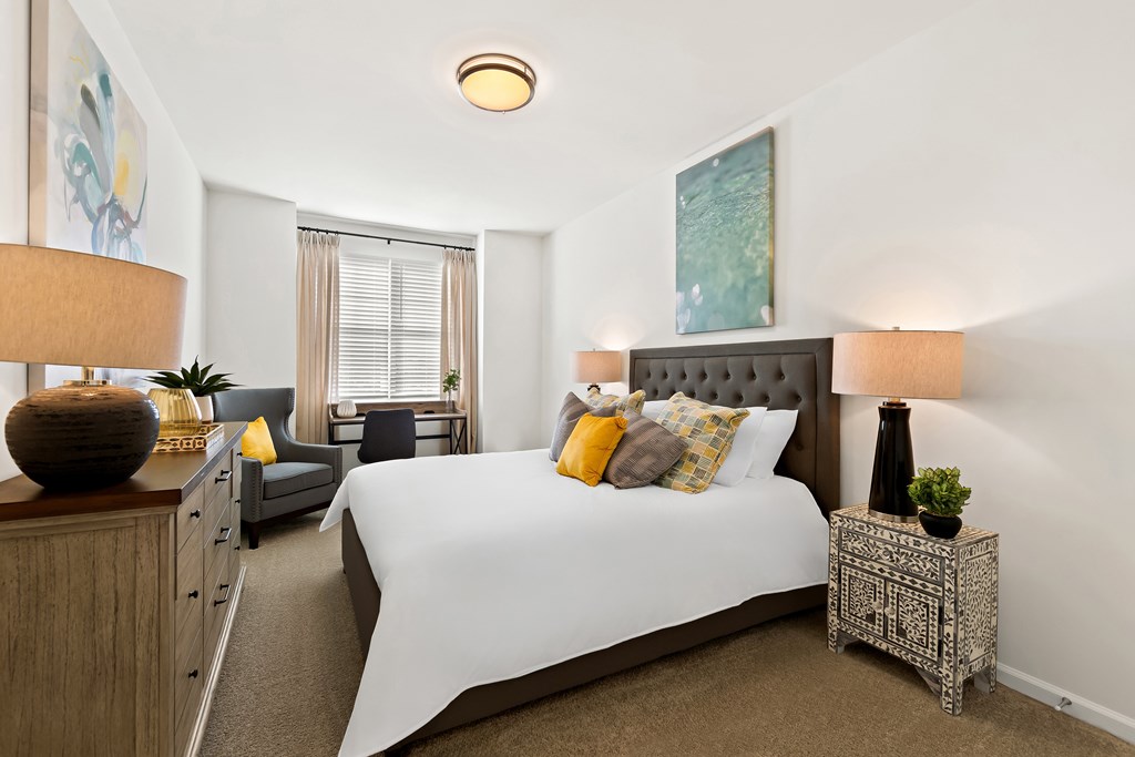 A bedroom with a large bed and a painting on the wall.
