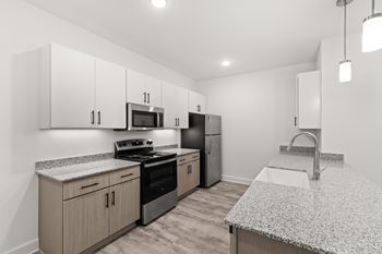 A kitchen with granite countertops and stainless steel appliances.