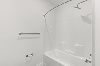 A white bathroom with a shower and a bathtub.