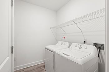 A white washing machine and dryer in a small laundry room.