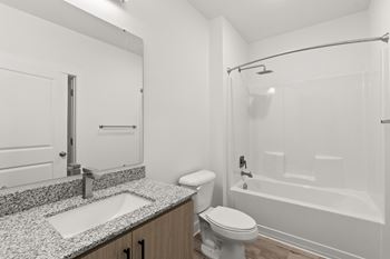 A white bathroom with a sink, toilet, and bathtub.
