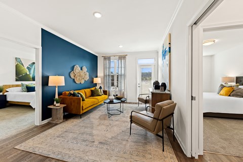 A living room with a yellow couch and a brown chair.