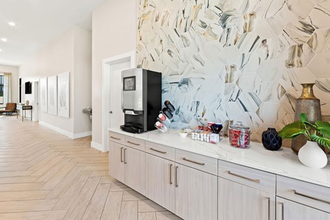 A kitchen with a white counter top and a coffee maker on it.